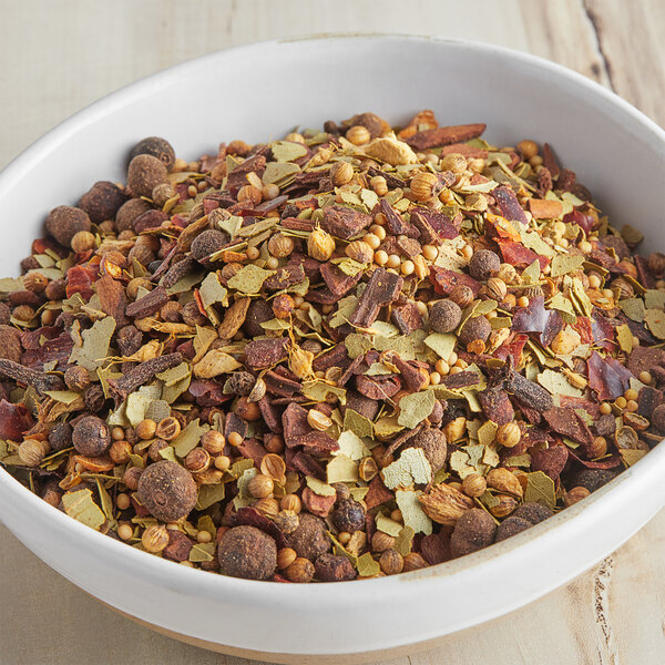 A bowl of McCormick Culinary Pickling Spice on a wood surface.