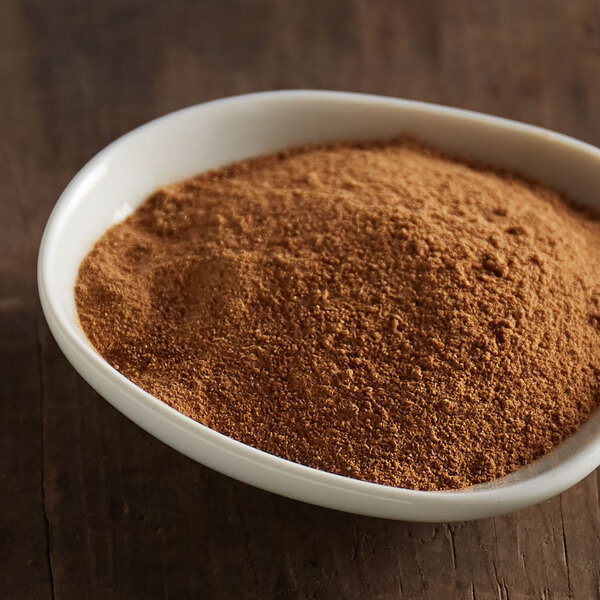 A bowl of brown McCormick Culinary Pumpkin Pie Spice powder on a table.