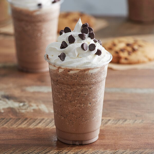 A cup of Big Train Java Chip Blended Ice Coffee with whipped cream and chocolate chips on top.