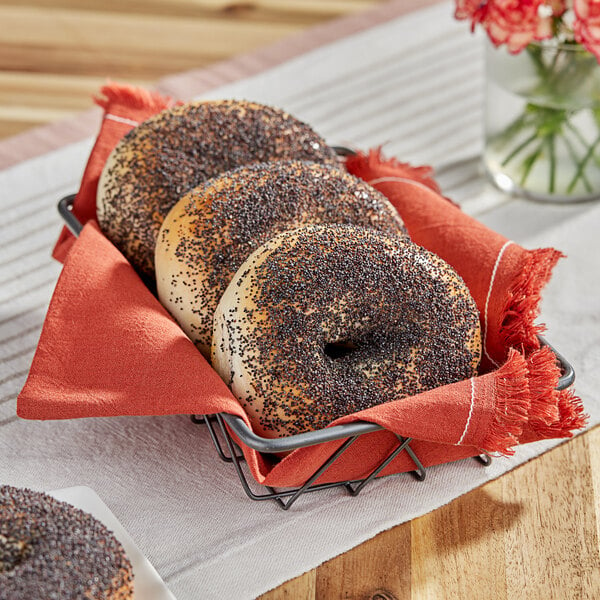 A basket of bagels with poppy seeds.