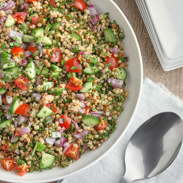 A bowl of salad with tomatoes, cucumbers, onions, and McCormick Guacamole and More seasoning.