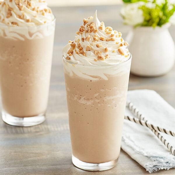 Two glasses of Big Train toffee mocha blended ice coffee with whipped cream and nuts.