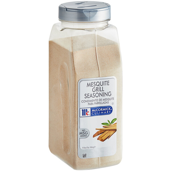 A clear container of brown McCormick Mesquite Grill Seasoning.