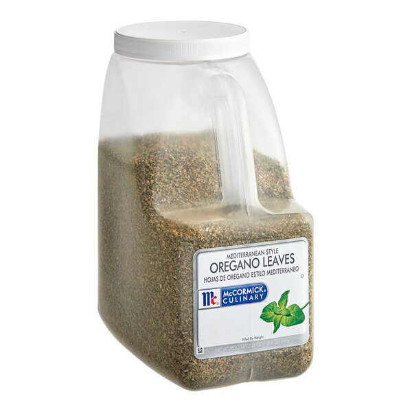 A clear plastic container of McCormick Culinary Mediterranean Oregano with green leaves inside.
