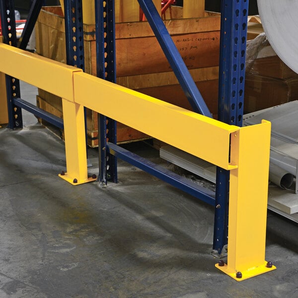 A yellow adjustable steel rack guard installed in a warehouse for protecting shelving units.