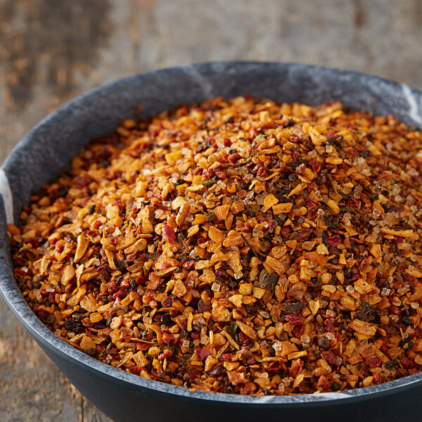 A bowl of McCormick Grill Mates BBQ seasoning on a wood surface.