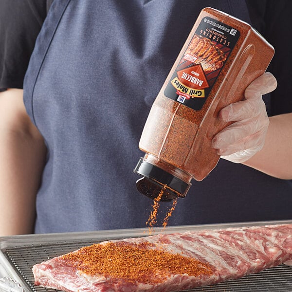 A person pouring McCormick Grill Mates BBQ Seasoning on a piece of meat.