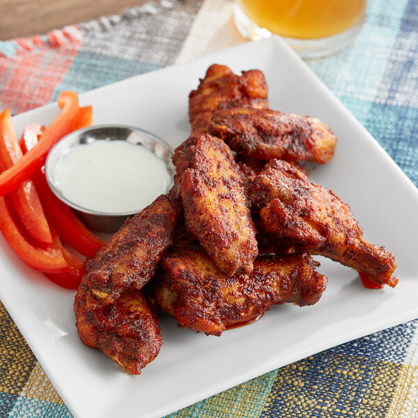 A plate of chicken wings with Frank's RedHot Nashville Hot Seasoning and a side of ranch dip.