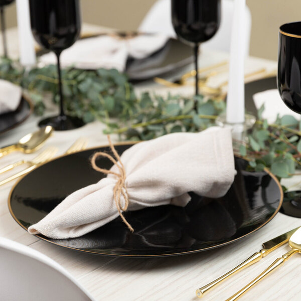 A table set with black Posh Setting charger plates with gold rims.
