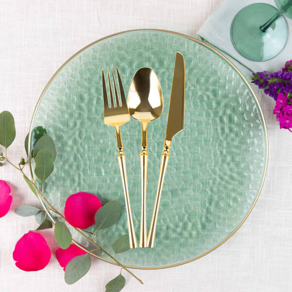 A close-up of a Posh Setting gold plastic spoon.