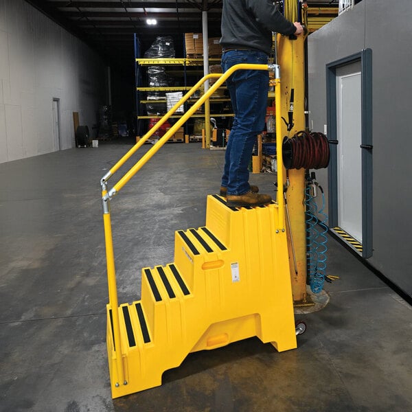 A yellow polyethylene four-step step stool with handrails and casters, designed for industrial use.
