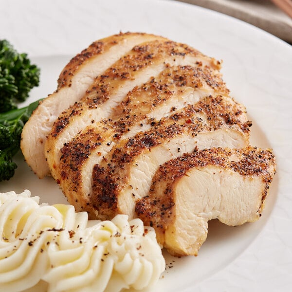 A plate of food with a slice of chicken, mashed potatoes, and broccoli seasoned with Lawry's Garlic Pepper.