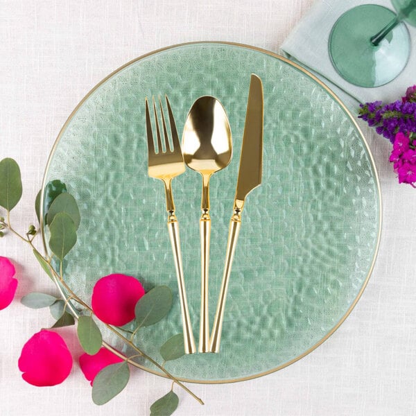 A close-up of a Posh Setting gold plastic knife with a metal tip.