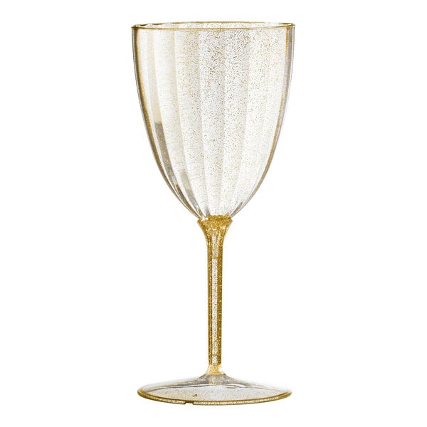 A clear plastic wine goblet with gold glitter on it.