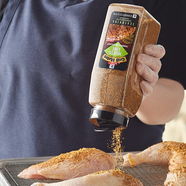 A person pouring McCormick Grill Mates Mojito Lime seasoning onto a piece of meat.