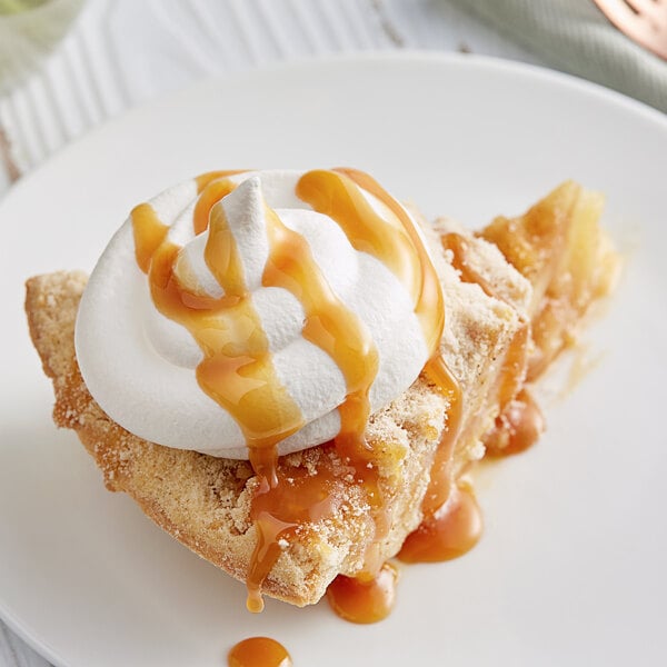 A piece of pie with whipped cream and DaVinci Gourmet Caramel Sauce.