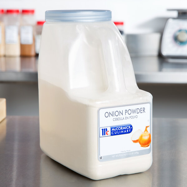 A case of three McCormick Culinary Onion Powder containers on a counter.
