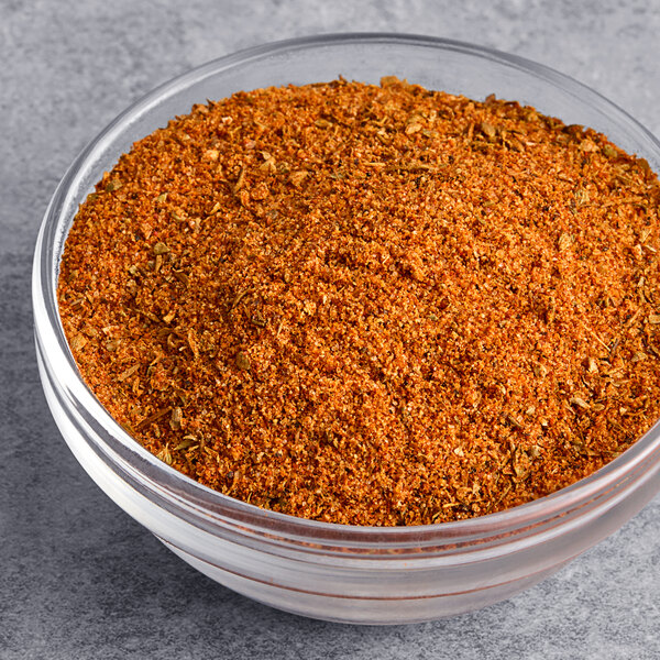 A bowl of ground spices on a gray surface.