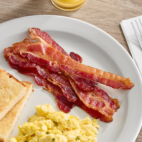 A plate of Daily's bacon, scrambled eggs, and toast on a table.