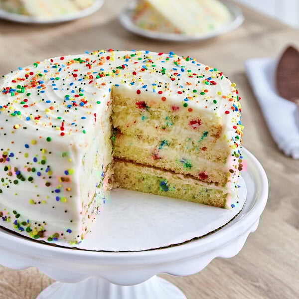A round layer cake with white frosting and colorful sprinkles, made from Pillsbury Funfetti cake mix.