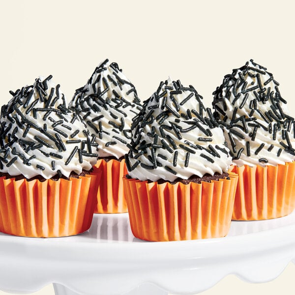 A cupcake with black sprinkles on top.