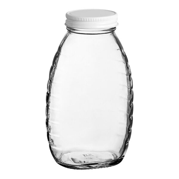 A clear glass Classic Queenline honey jar with a white metal lid.