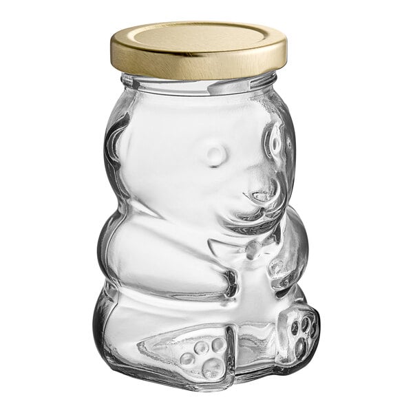 A clear glass bear jar with a gold metal lid.