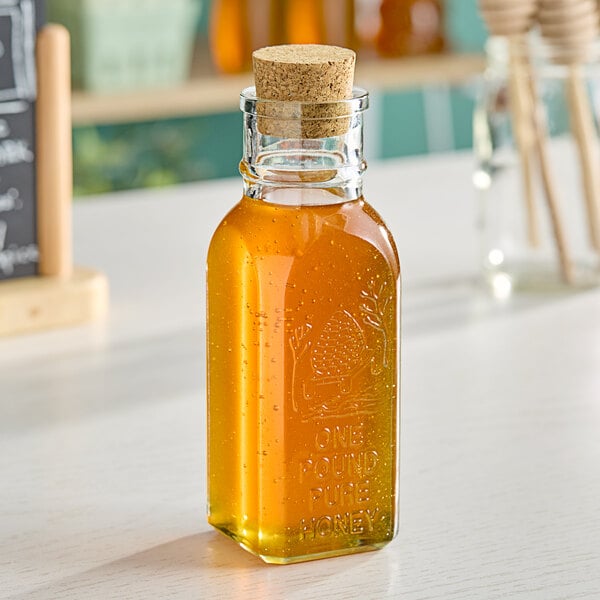 A 12 oz. glass Muth honey jar on a table.