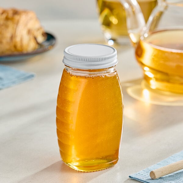 A Classic Queenline glass honey jar on a table.