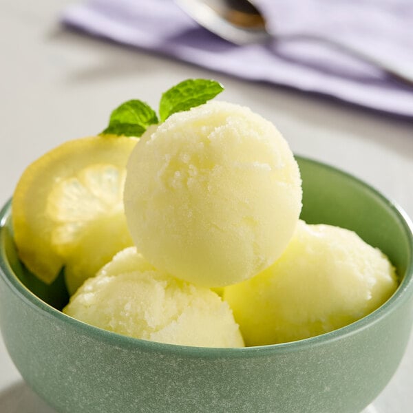 A bowl of lemon sorbet with a lemon slice on top.