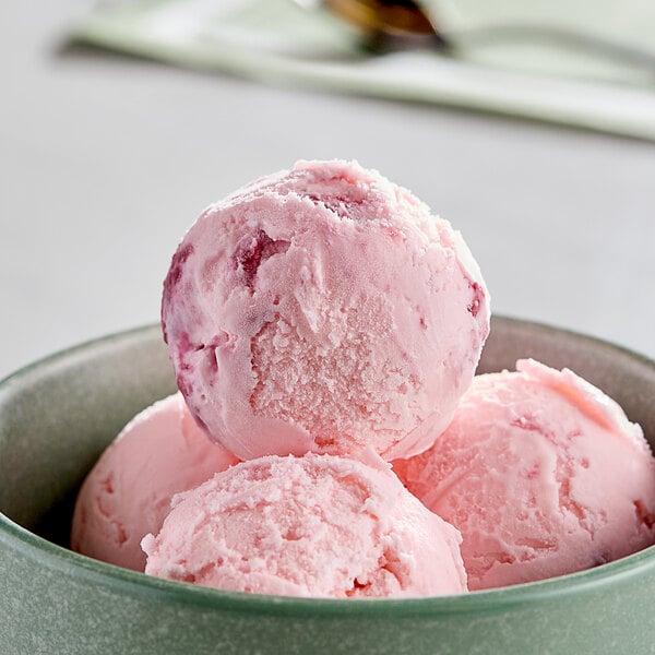 A bowl of pink and white swirled ice cream with a scoop on top.