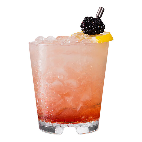 A Tossware stackable rocks glass with a drink, ice, and fruit.