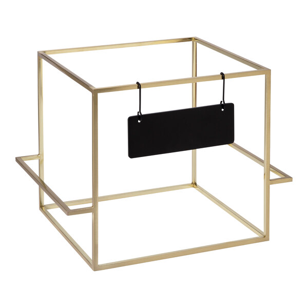A gold square riser with a black sign hanging from a metal bar.
