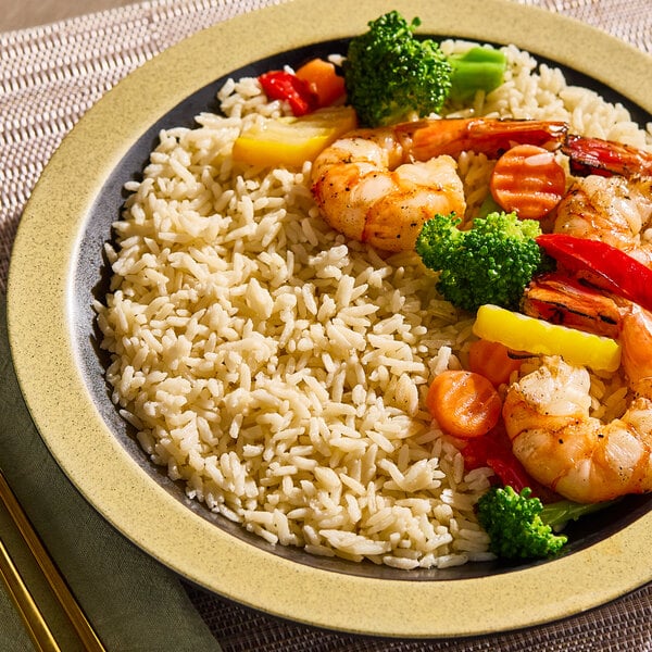 A plate of cooked jasmine rice served with shrimp and mixed vegetables.