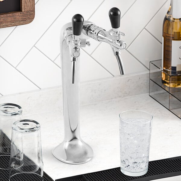 A Narvon undercounter water dispenser with a tap for chilled water and a glass of ice on a white counter.
