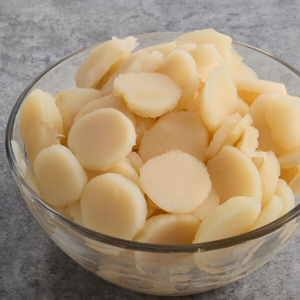 A glass bowl filled with sliced water chestnuts.