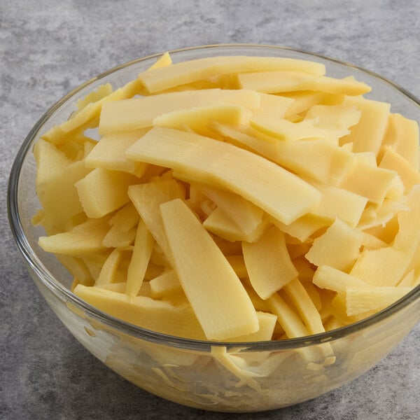 A glass bowl filled with sliced bamboo shoots.