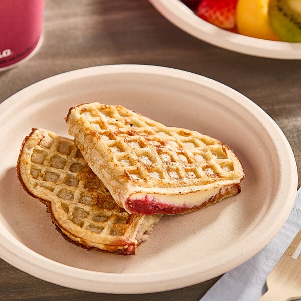 A Nordic Waffles Berries and Cream Waffle sandwich on a plate with fruit in the background.