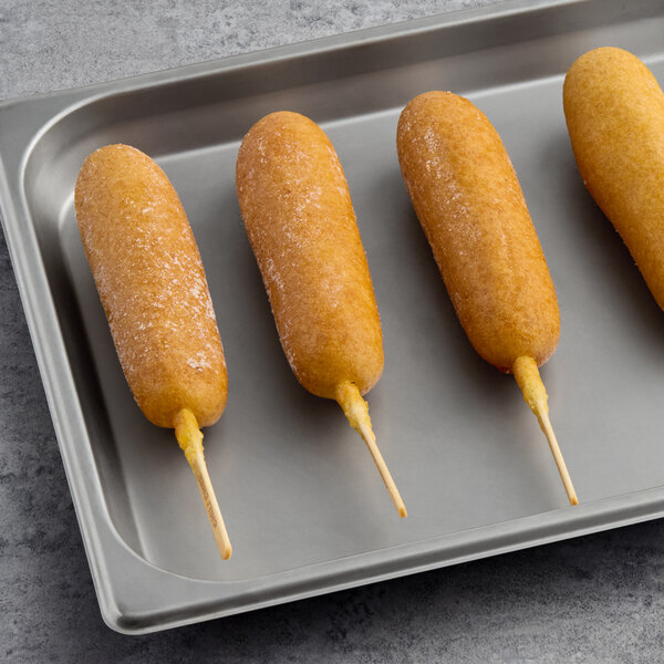 A tray of 6 Foster Farms chili cheese chicken corn dogs on a counter.