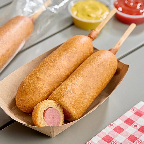Two Foster Farms whole grain corn dogs on a stick in a paper boat.