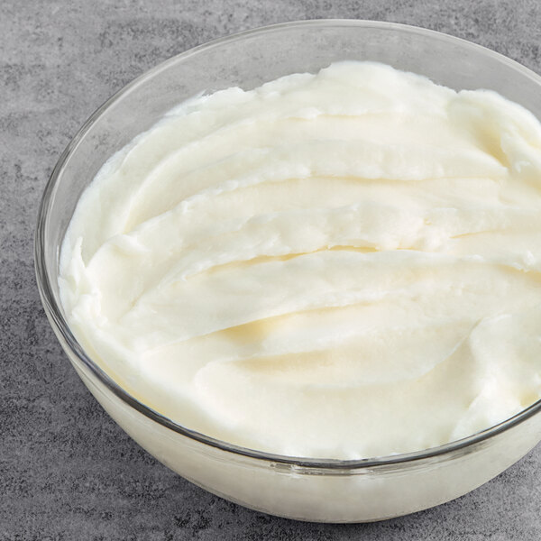 A Butcher Boy lard pail next to a bowl of whipped cream.