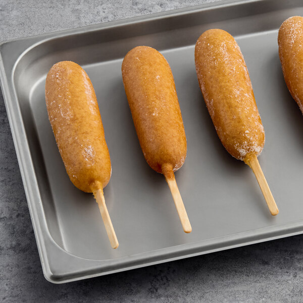 A tray of Foster Farms Chicken Corn Dogs on a stick.