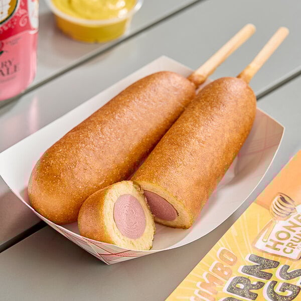A pink box of Foster Farms Honey Chicken Corn Dogs on a table.