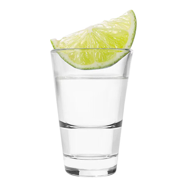 A Tossware stackable shot glass with a lime wedge in it.