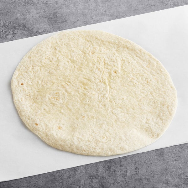 An El Mejor flour tortilla on a white surface.