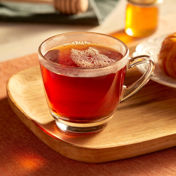 A glass cup of Bigelow English Breakfast Tea on a wooden tray.