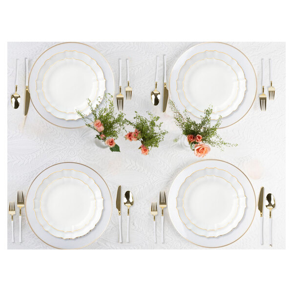 A white table setting with a Posh Setting gold and white plastic spoon on a white and gold plate.