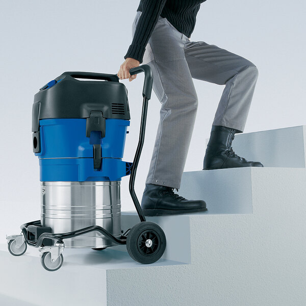 A man using a Nilfisk wet/dry vacuum cleaner.