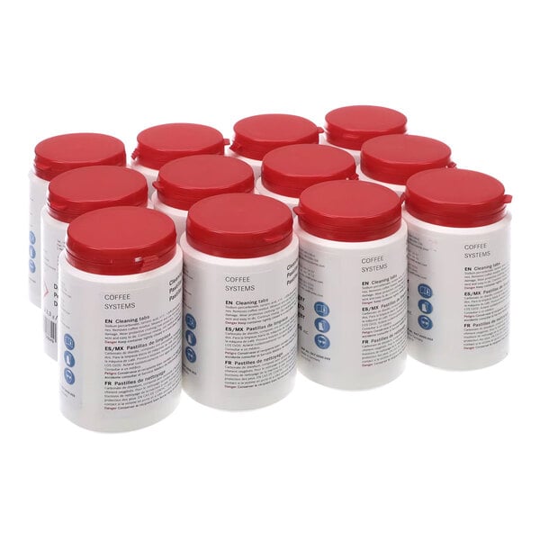 A group of Franke coffee machine cleaning tablets in white containers with red lids.