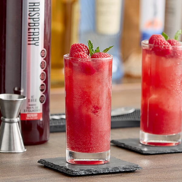 Two glasses of SHOTT raspberry drink on a table.